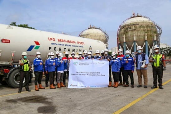 Group photo with an LPG skid tank transport vehicle in the background